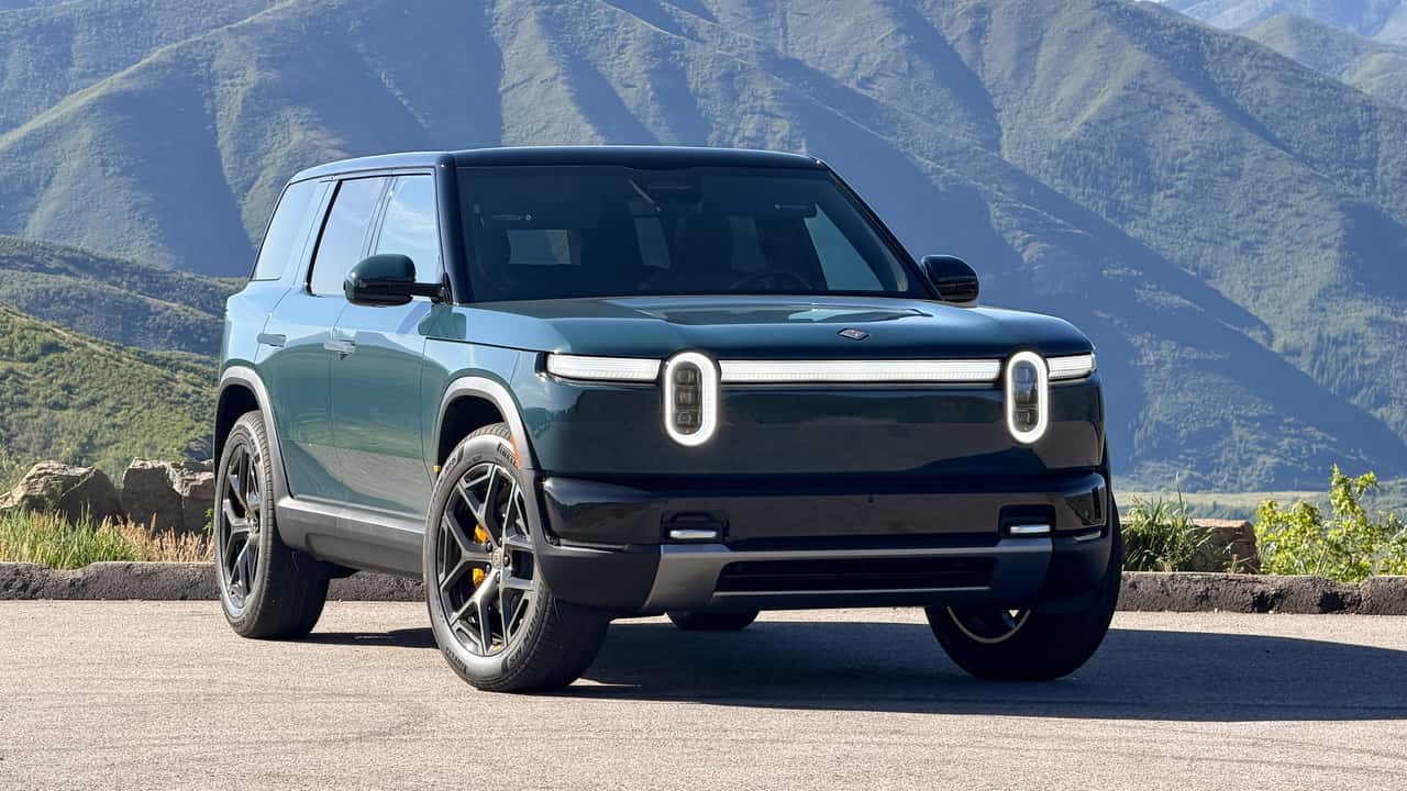 Rivian R2 driving off-road through rugged terrain during first drive event - real off-road capability